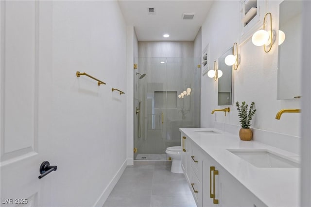 bathroom featuring vanity, toilet, and a shower with shower door