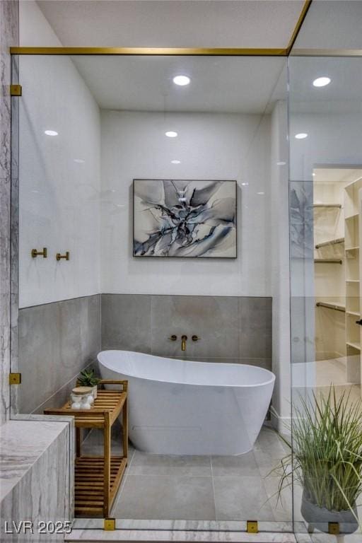 bathroom with tile walls and a bathing tub