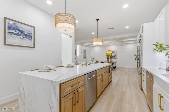 kitchen featuring a large island with sink, dishwasher, pendant lighting, and sink