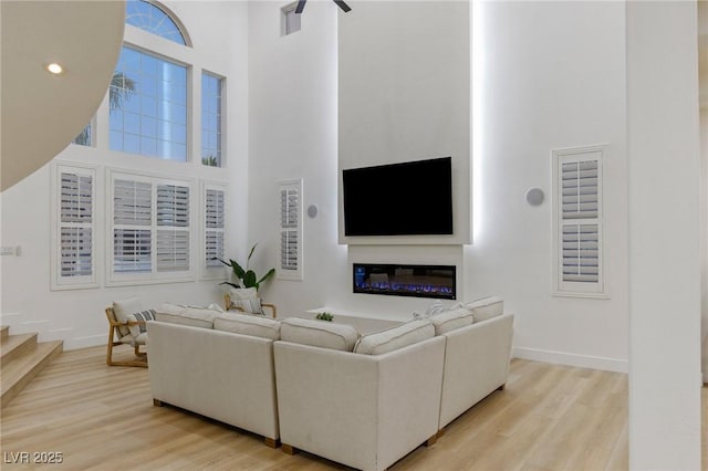 living room with a towering ceiling and light hardwood / wood-style floors