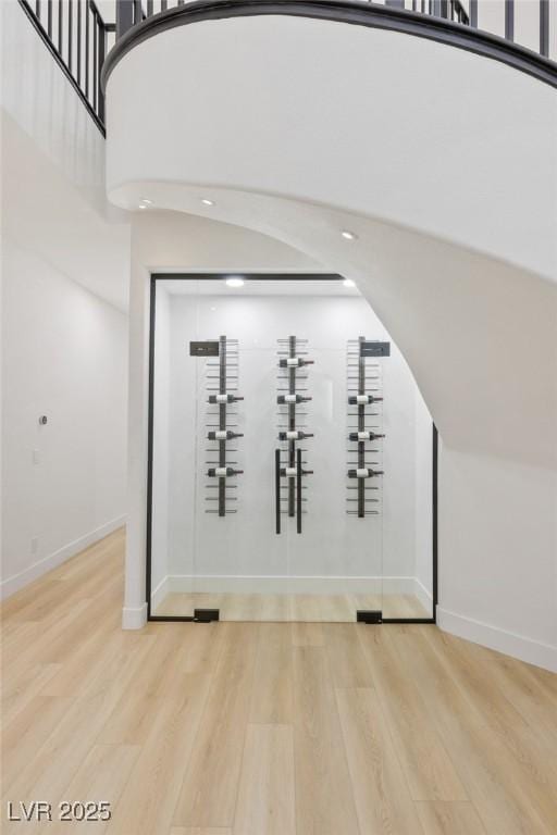 wine cellar with a high ceiling and light hardwood / wood-style floors