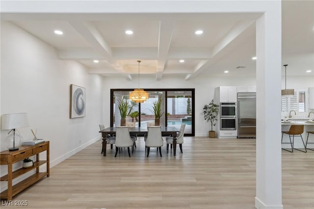 dining room featuring beam ceiling, light hardwood / wood-style flooring, a chandelier, and coffered ceiling