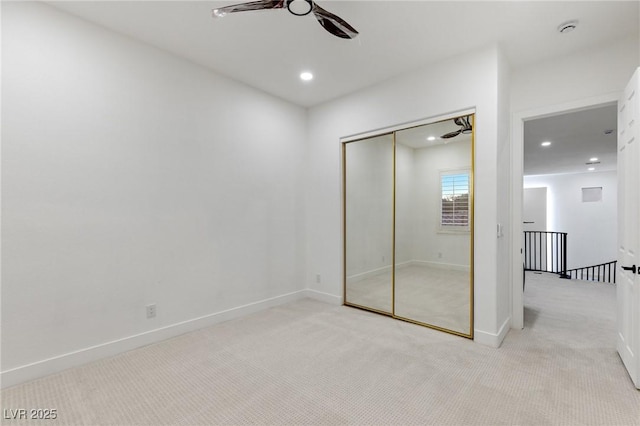 unfurnished bedroom featuring ceiling fan, light carpet, and a closet