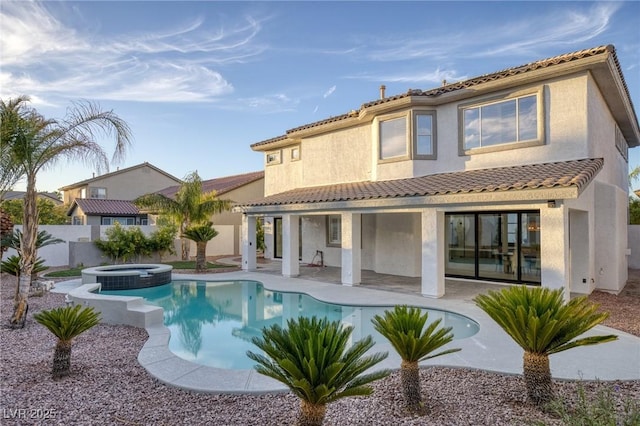 back of house with a patio area and a swimming pool with hot tub