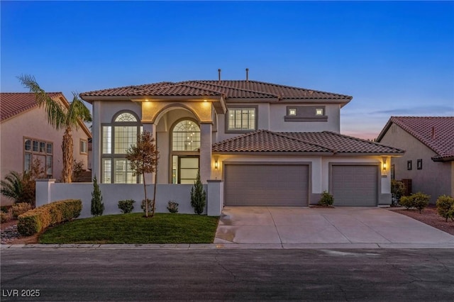 mediterranean / spanish-style house featuring a lawn and a garage