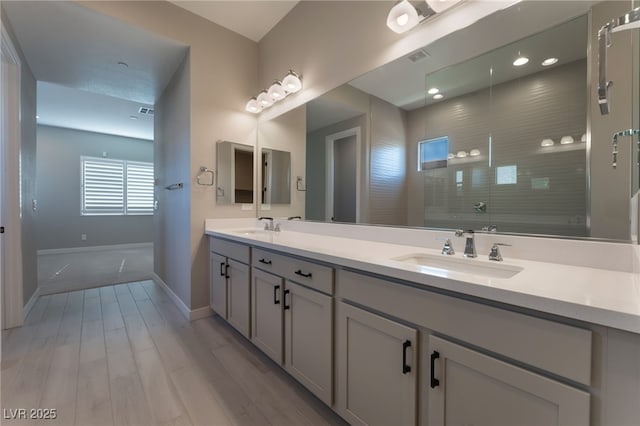 bathroom featuring a tile shower, vanity, and hardwood / wood-style flooring