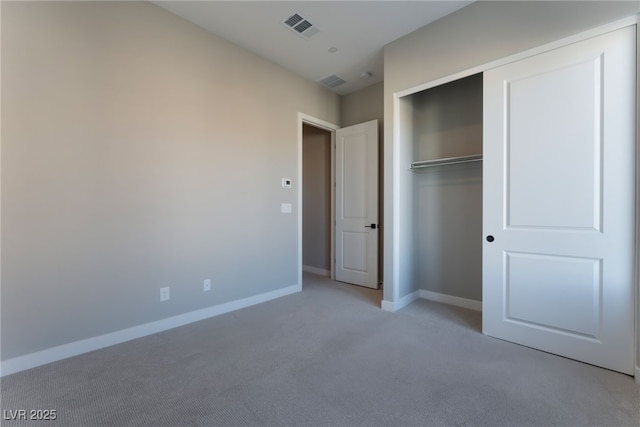 unfurnished bedroom featuring light carpet and a closet