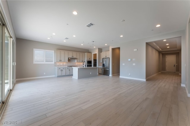 unfurnished living room with light hardwood / wood-style flooring and sink