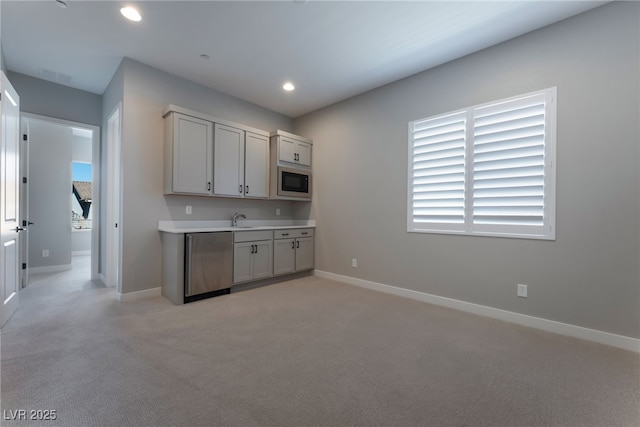 kitchen with light carpet, white cabinets, built in microwave, sink, and dishwasher