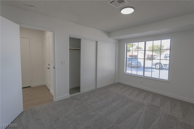 unfurnished bedroom featuring carpet flooring and a closet