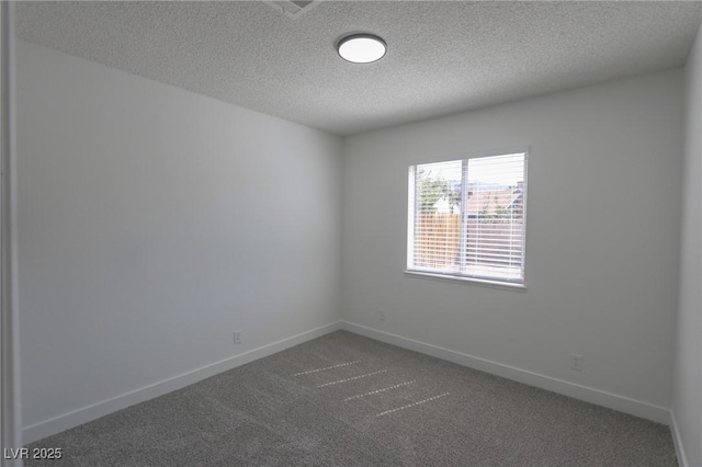 empty room with dark colored carpet and a textured ceiling