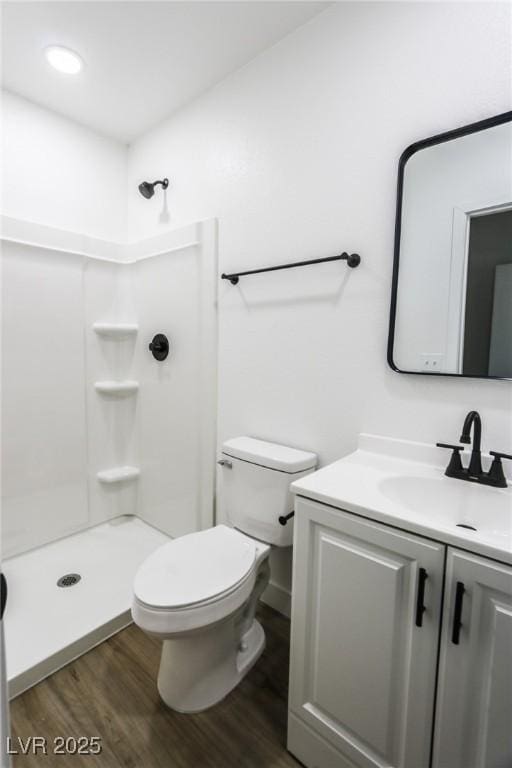 bathroom featuring vanity, hardwood / wood-style flooring, toilet, and walk in shower