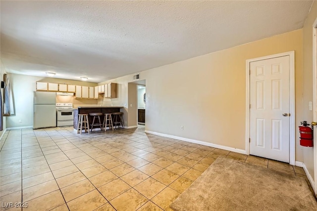 unfurnished living room featuring light tile patterned flooring and a textured ceiling