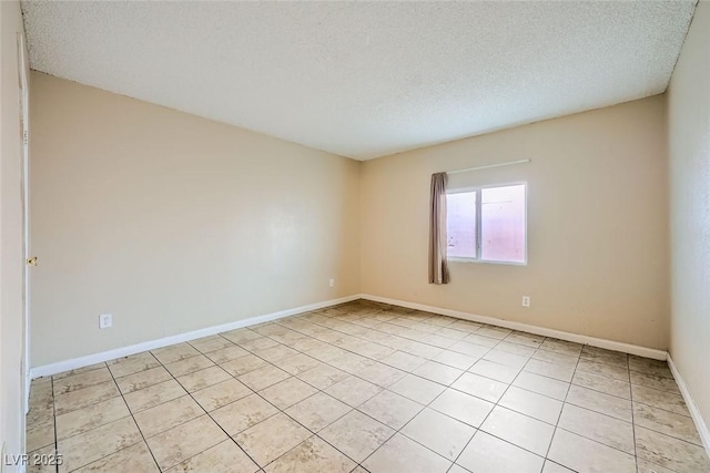 tiled empty room featuring a textured ceiling