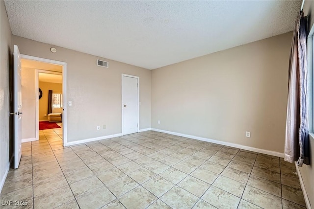 unfurnished bedroom with a textured ceiling and light tile patterned flooring