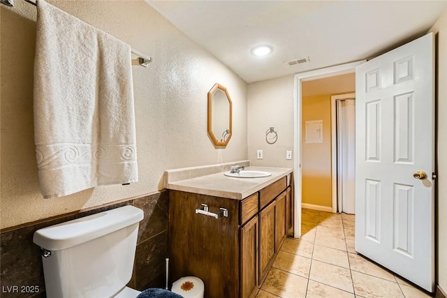 bathroom featuring toilet, tile patterned flooring, and vanity