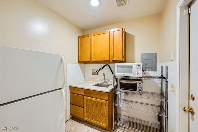 kitchen with electric panel, sink, white appliances, and light tile patterned flooring