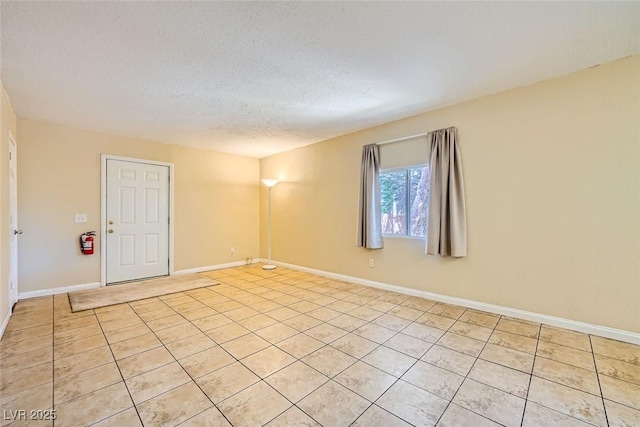 unfurnished room featuring light tile patterned floors and a textured ceiling