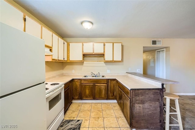 kitchen with exhaust hood, kitchen peninsula, a breakfast bar area, white appliances, and sink