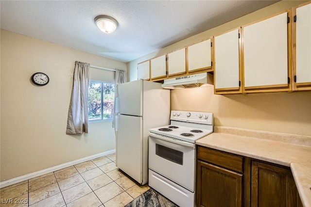 kitchen with light tile patterned flooring, white appliances, white cabinetry, and a textured ceiling