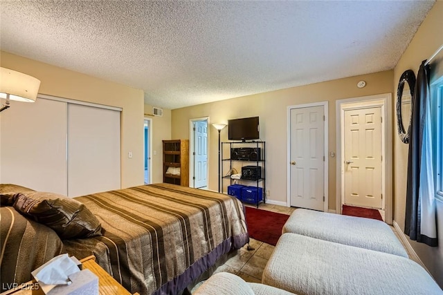 bedroom featuring light tile patterned flooring and a textured ceiling