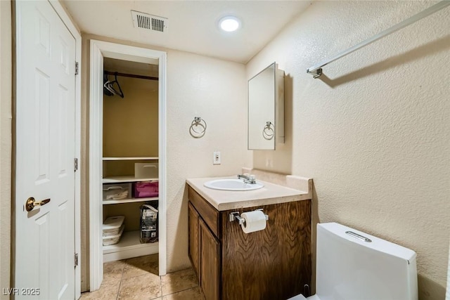 bathroom featuring toilet, vanity, and tile patterned flooring