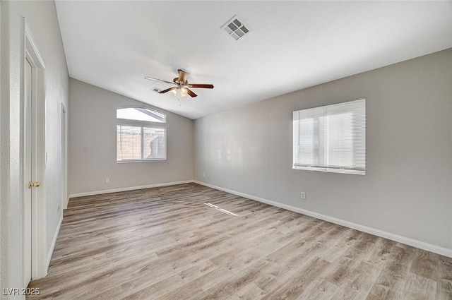 empty room featuring lofted ceiling, light wood-type flooring, and ceiling fan