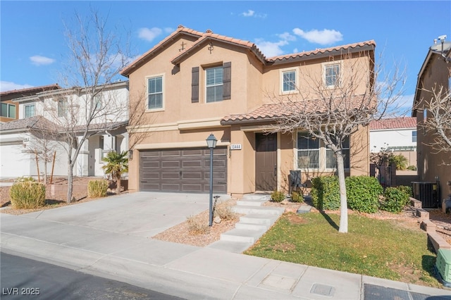 mediterranean / spanish-style home featuring a garage and central air condition unit