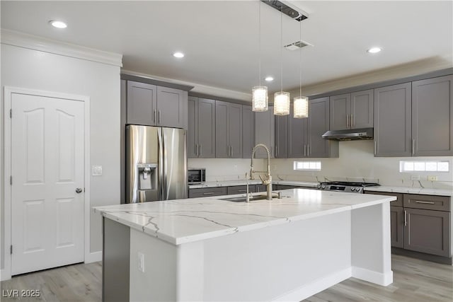 kitchen featuring gray cabinetry, under cabinet range hood, a sink, stainless steel fridge with ice dispenser, and stove