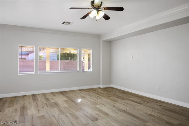 spare room with light hardwood / wood-style floors, plenty of natural light, ornamental molding, and ceiling fan