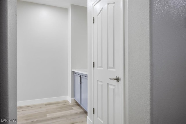 hallway featuring light wood-style floors and baseboards