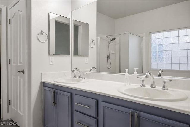 bathroom featuring double vanity, a stall shower, and a sink