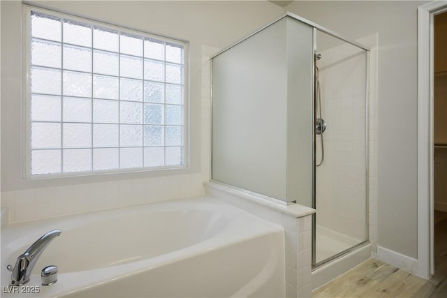 bathroom featuring a shower stall and a garden tub