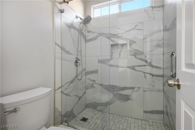 bathroom featuring a marble finish shower and toilet