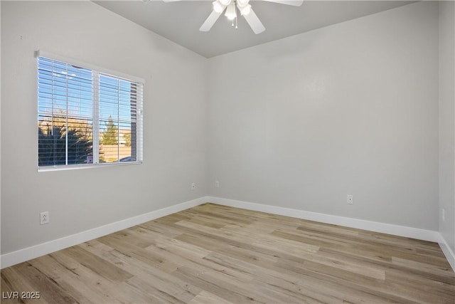 spare room featuring baseboards, a ceiling fan, and light wood finished floors