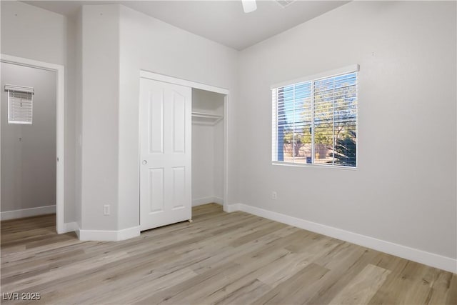 unfurnished bedroom with a closet, ceiling fan, baseboards, and light wood-style floors