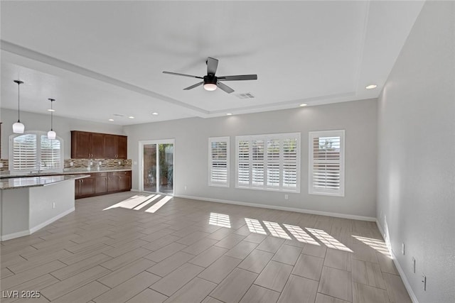 unfurnished living room with ceiling fan and plenty of natural light