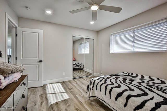 bedroom featuring a closet, light hardwood / wood-style floors, and ceiling fan