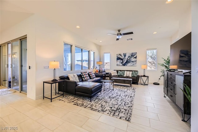 living room featuring light tile patterned floors, ceiling fan, and a wealth of natural light