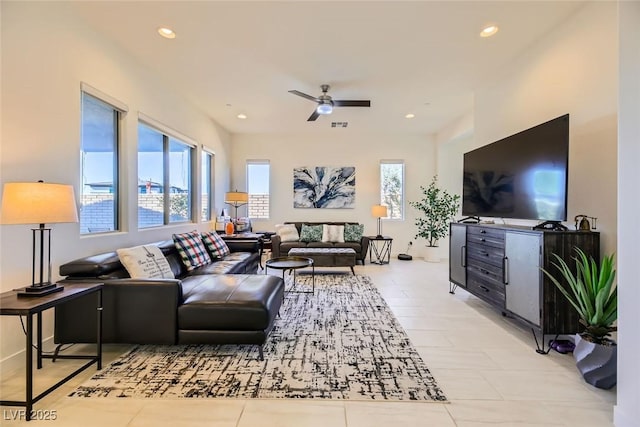 tiled living room featuring ceiling fan and a water view