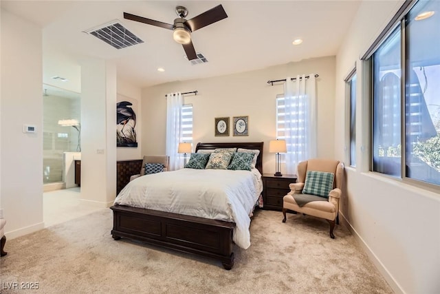 carpeted bedroom with ceiling fan, ensuite bath, and multiple windows