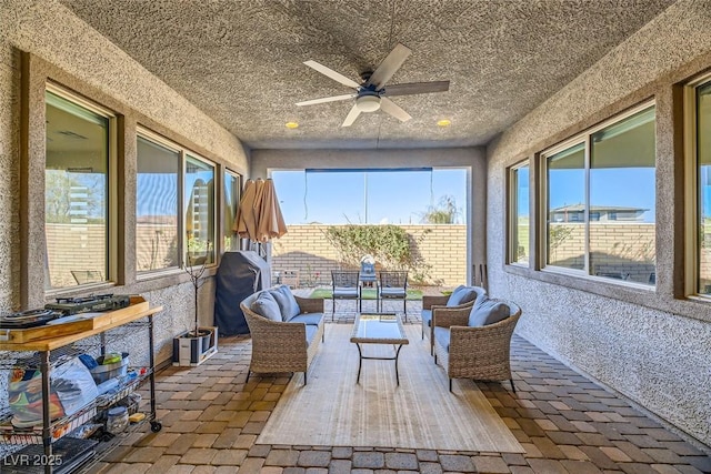 sunroom / solarium featuring ceiling fan