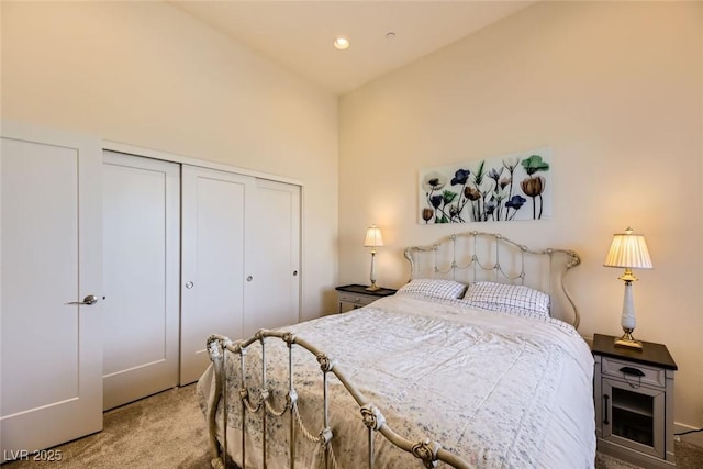 bedroom featuring light carpet, a closet, and lofted ceiling