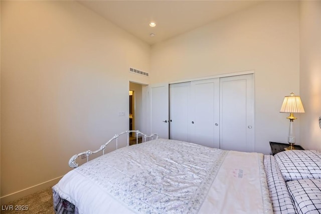 carpeted bedroom featuring high vaulted ceiling and a closet