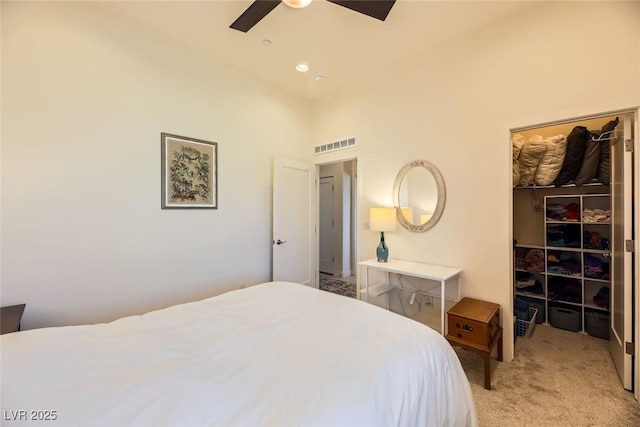 bedroom featuring ceiling fan, a towering ceiling, light carpet, a walk in closet, and a closet