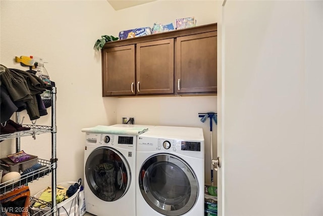 laundry area with separate washer and dryer and cabinets