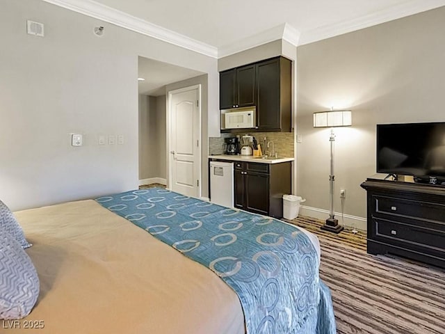 bedroom featuring light wood-type flooring, crown molding, and ensuite bath