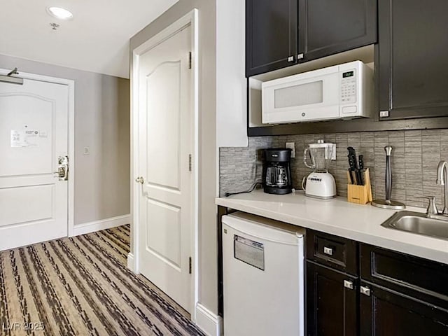 kitchen with backsplash, sink, and white appliances