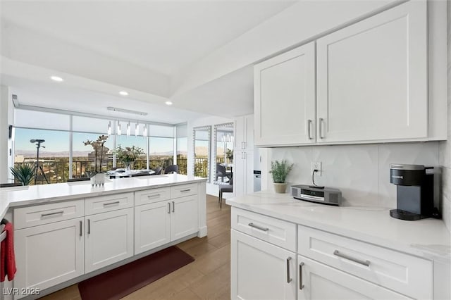 kitchen featuring light stone counters, white cabinetry, and light hardwood / wood-style flooring