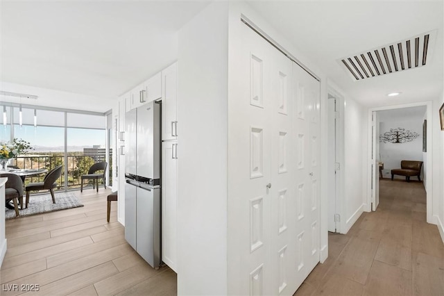 corridor featuring floor to ceiling windows and light hardwood / wood-style flooring